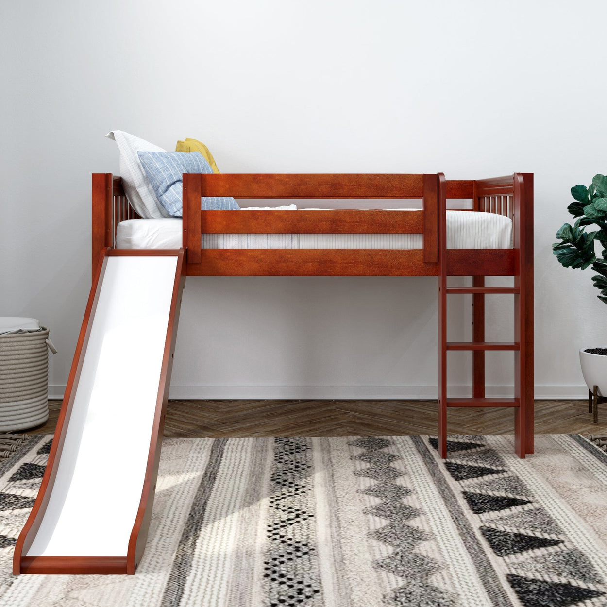 Wooden loft bed with slide and ladder in a bright children's room with patterned rug and plant.