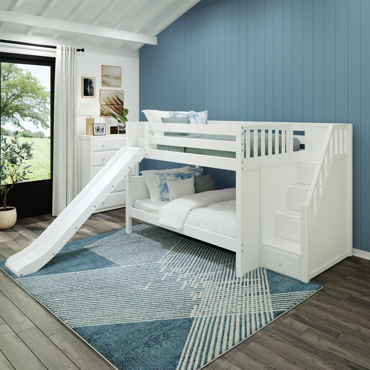 White bunk bed with slide and storage stairs in a modern children's bedroom with blue walls and geometric rug.