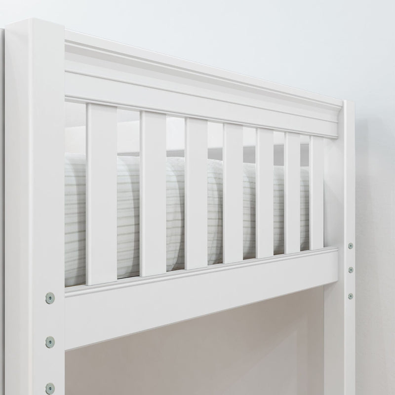 Close-up of white wooden crib rail with vertical slats and safety guardrail for modern nursery