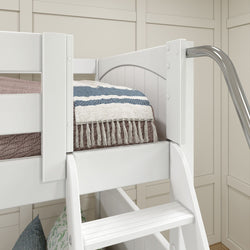 White bunk bed corner with blue and white striped blanket and modern slide in a stylish kids' bedroom.