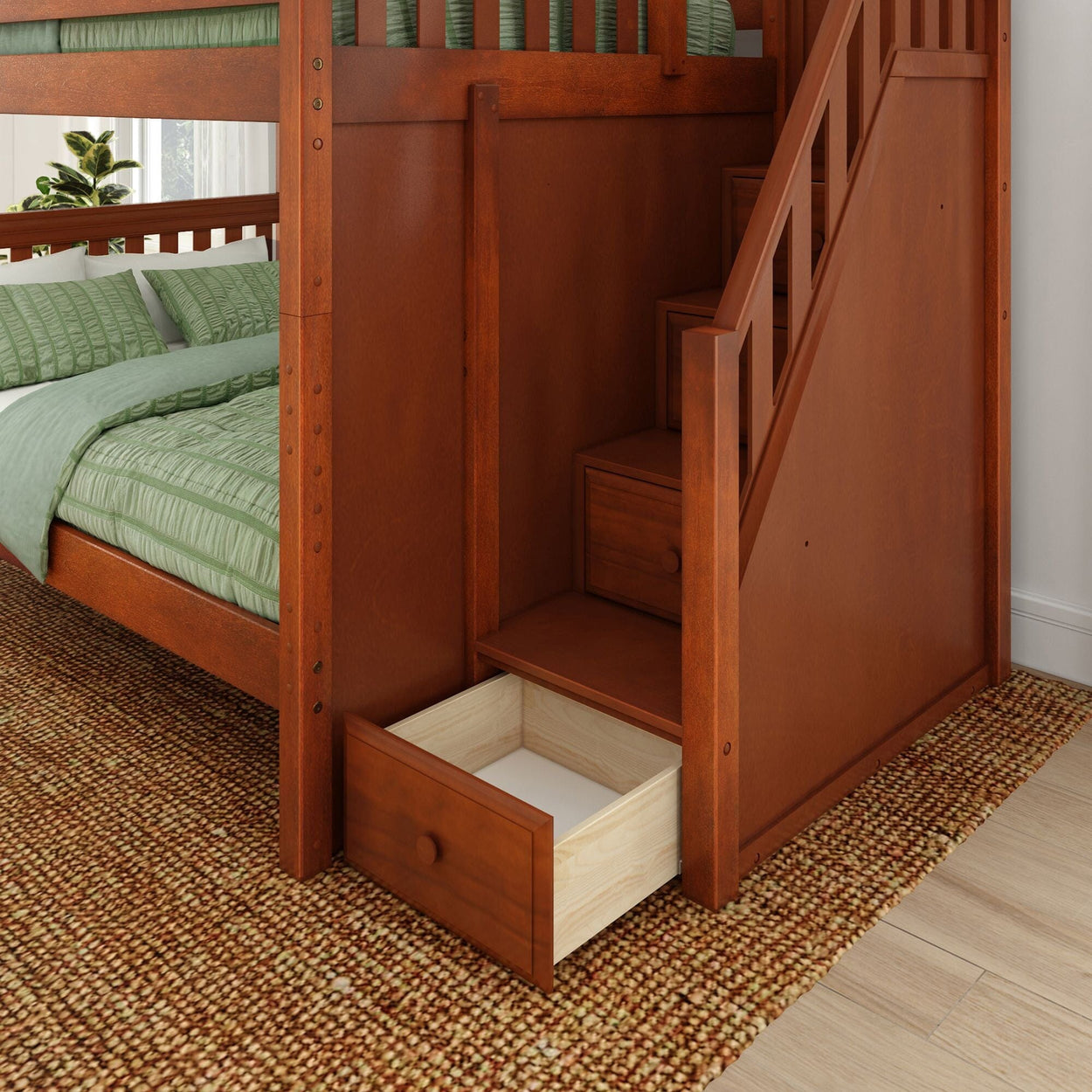 Wooden bunk bed with built-in staircase storage and open drawer, featuring green bedding on patterned carpet.