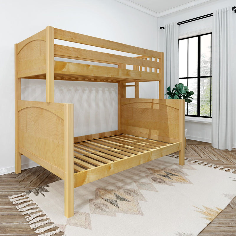 Solid natural wood twin-over-full bunk bed with slatted mattress support and ladder in a bright kids' bedroom with patterned rug, potted plant and large black-framed window