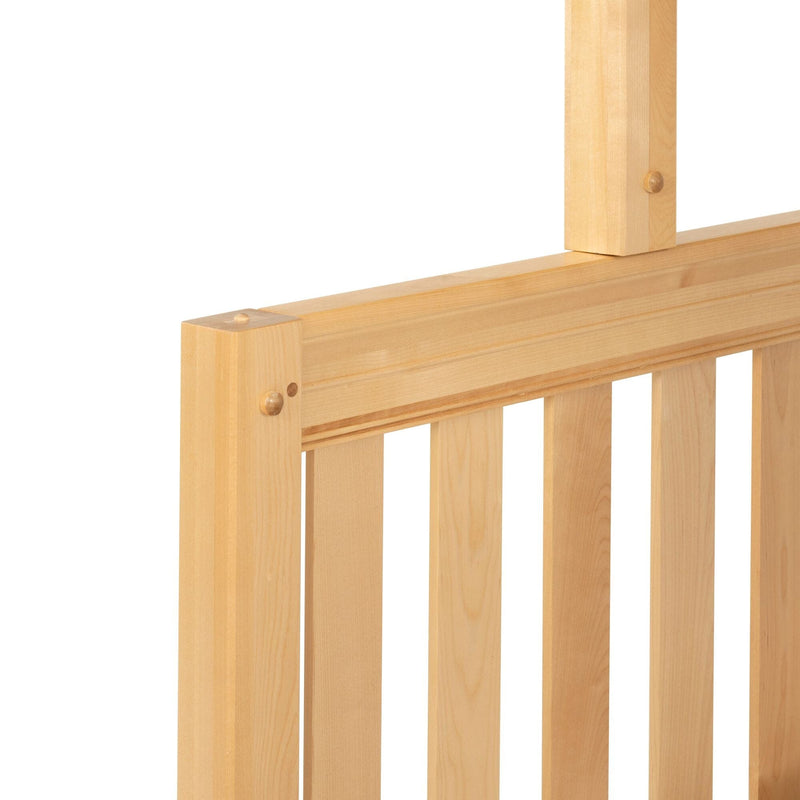Natural wooden slatted headboard close-up showing dowel-peg joinery on a light pine bed frame