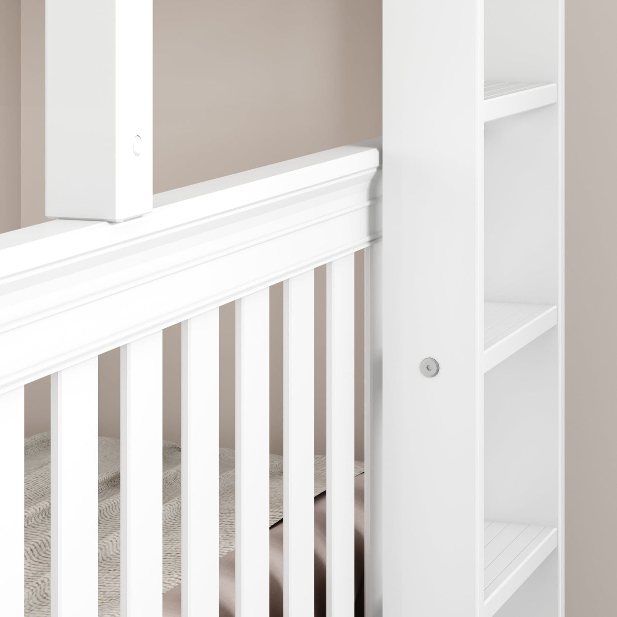 White baby crib with elegant side rails and built-in storage shelves against a beige wall.