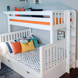 White bunk bed with colorful pillows and decorative bedding in a modern children's bedroom.