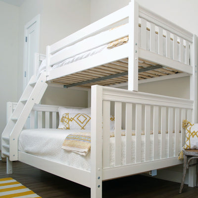 White wooden bunk bed in a modern bedroom with decorative pillows and cozy bedding.