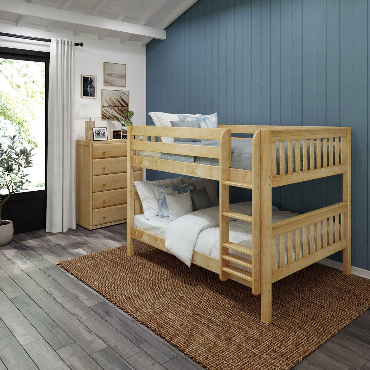 Wooden bunk bed in modern bedroom with blue accent wall and wooden dresser.