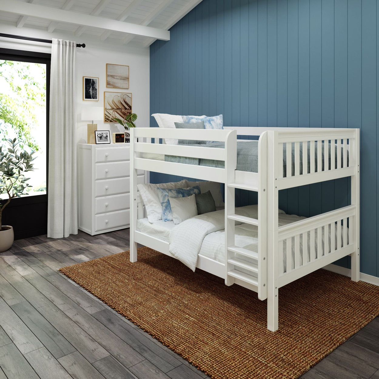 White wooden bunk bed in a cozy kids' room with blue accent wall and wooden floor.