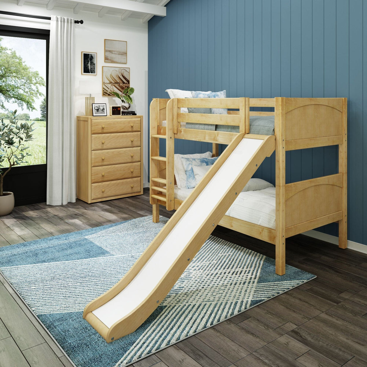 Children's wooden bunk bed with slide in modern bedroom, featuring blue accent wall and dresser.
