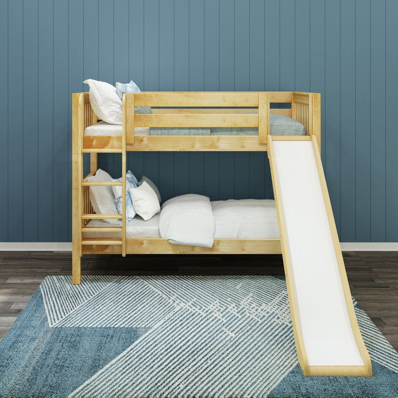 Natural wood bunk bed with slide in modern children's bedroom with blue paneled wall, white and blue bedding, and geometric blue area rug