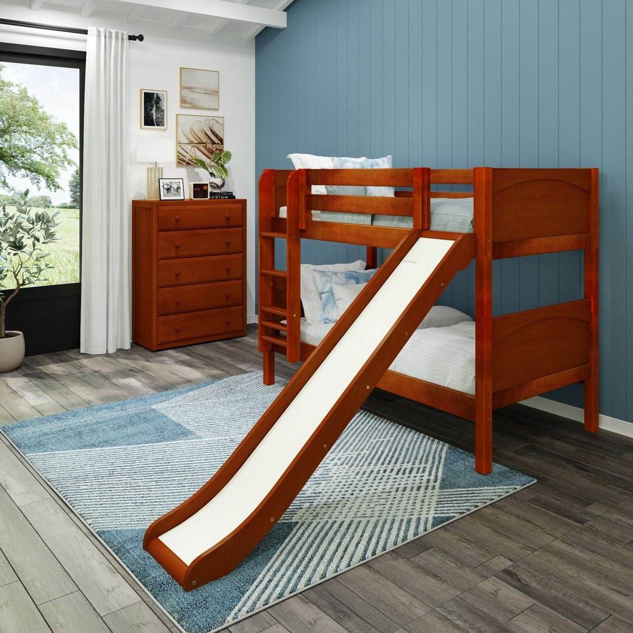Wooden bunk bed with slide in blue-themed kids' bedroom, featuring dresser and wall art.