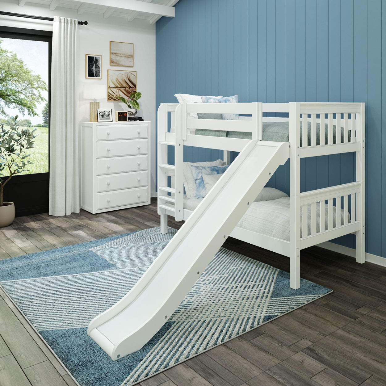 White bunk bed with slide in kids room featuring blue accent wall and wide window view.