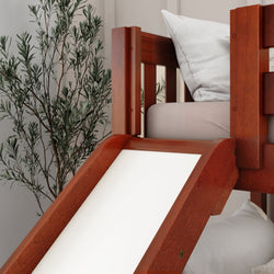 Wooden bunk bed with a slide and white cushion in a cozy room setting.