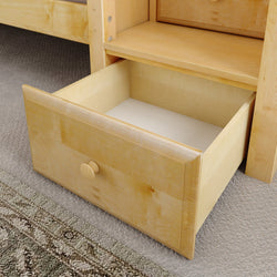 Open wooden drawer of a bed frame on carpet flooring.