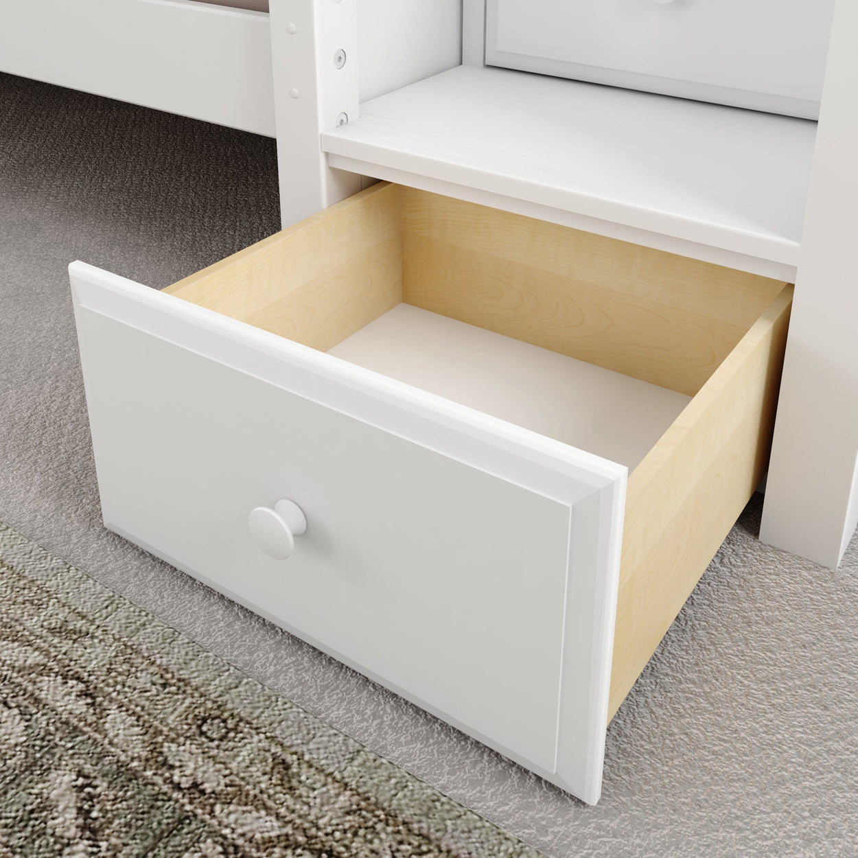 White wooden storage drawer unit with an open drawer on a carpeted floor.