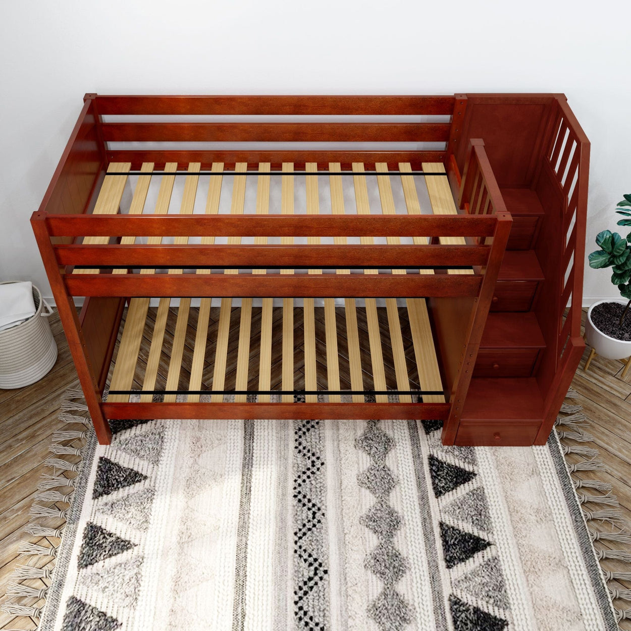 Wooden bunk bed with staircase and storage in a modern bedroom.