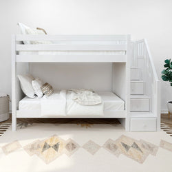 White wooden bunk bed with stairs in modern bedroom, featuring cozy bedding and decorative carpet.