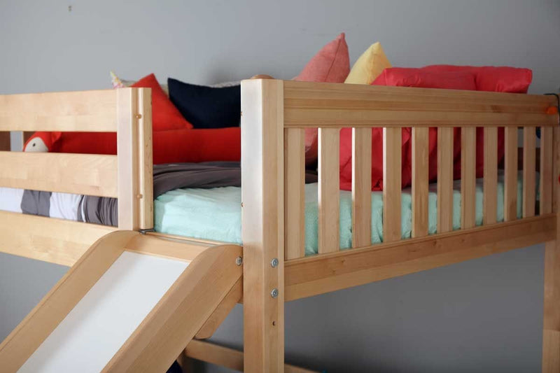 Natural pine loft bed with slide and safety rails, mint green bedding and colorful pillows in children's bedroom