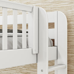 White wooden bunk bed frame with linens against a neutral textured wall background.