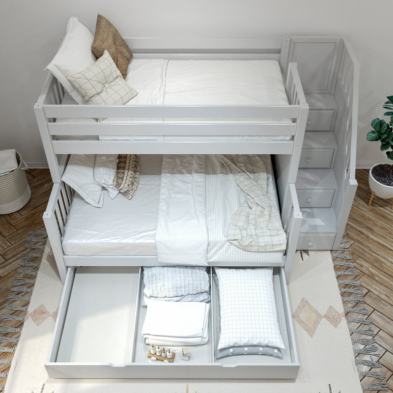 White wooden bunk bed with storage stairs and under-bed trundle drawer filled with folded bedding in a modern neutral kids' bedroom