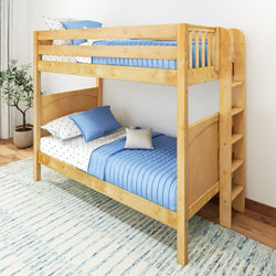 Wooden bunk bed with blue bedding in a bright bedroom setting with a patterned rug.