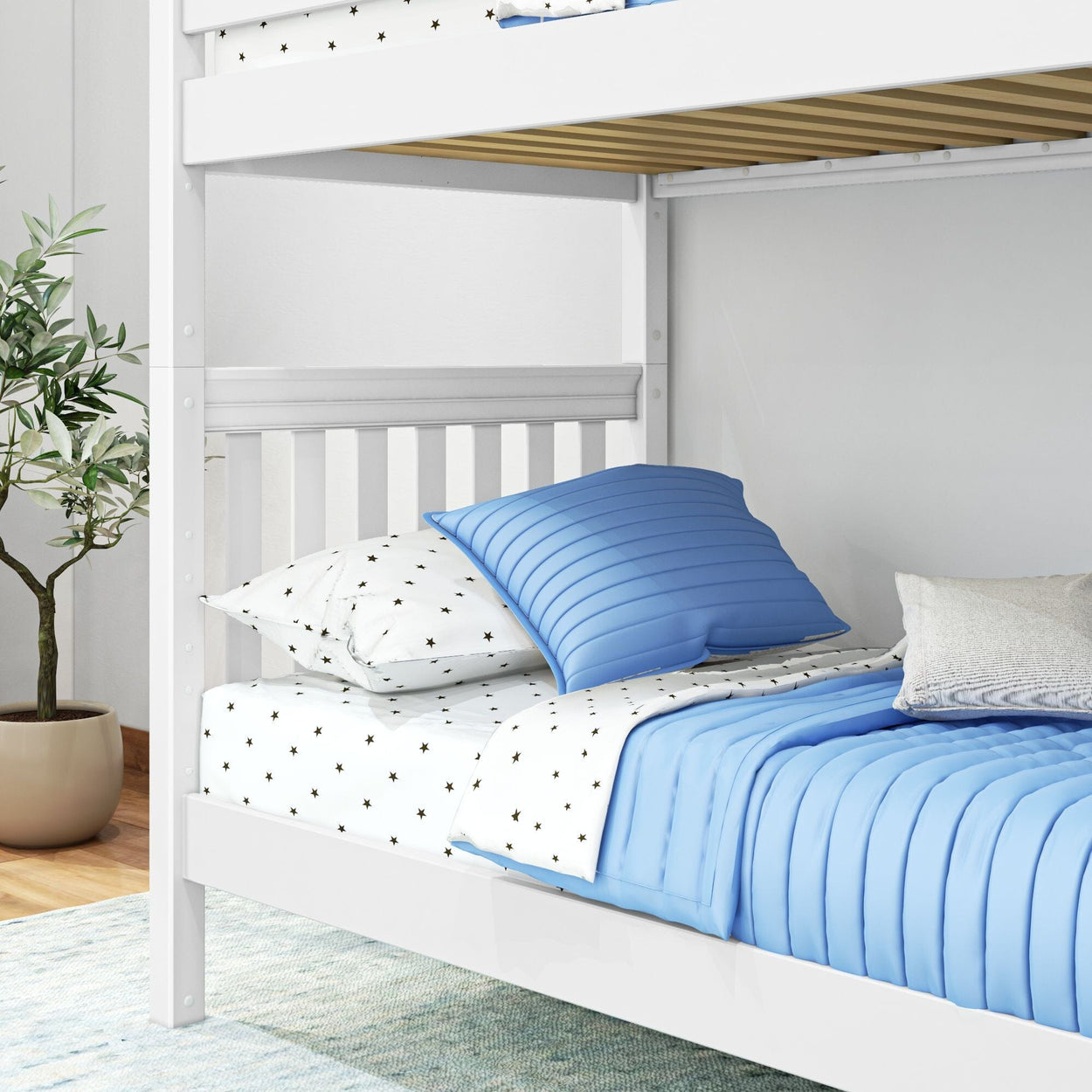 White bunk bed with blue bedding and star-patterned sheets in a cozy bedroom setting with plant decor.