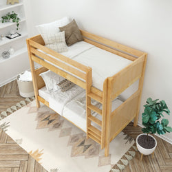 Wooden twin bunk bed with white and beige bedding in modern bedroom setting with a decorative plant and geometric-patterned rug.