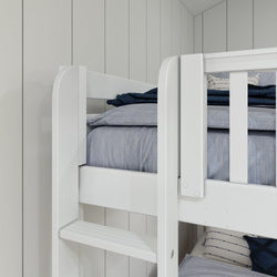 White bunk bed with blue bedding in a bright, modern bedroom with wooden panel walls.