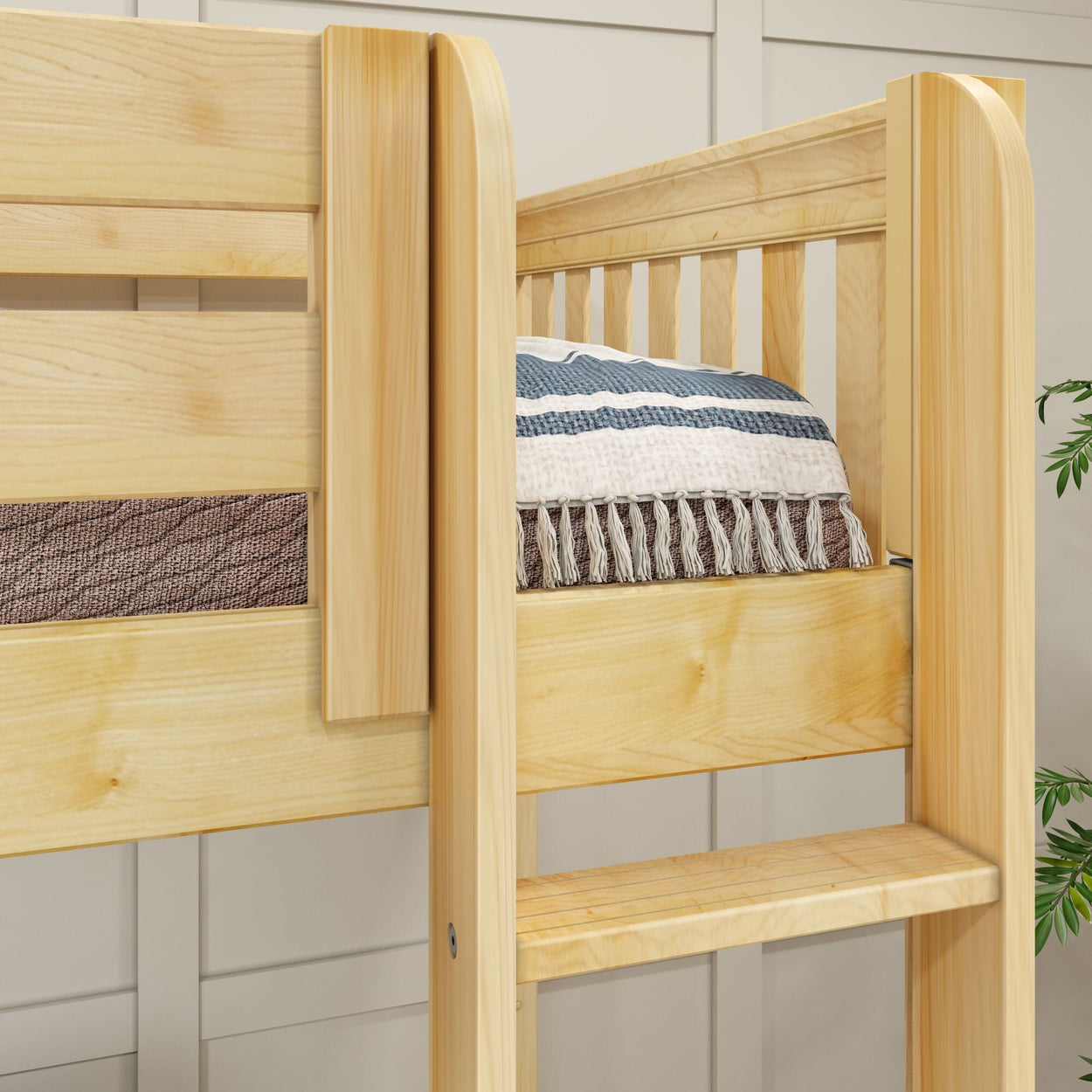 Wooden bunk bed with striped and fringed blanket in modern bedroom setting.