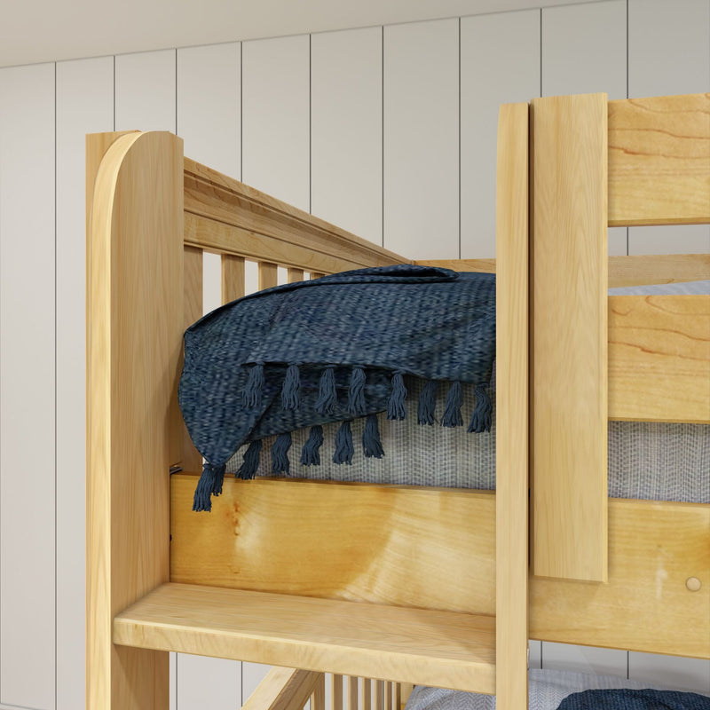 Close-up of a solid pine wooden bunk bed showing ladder, slatted guardrail and navy blue tasseled blanket against a white-paneled wall