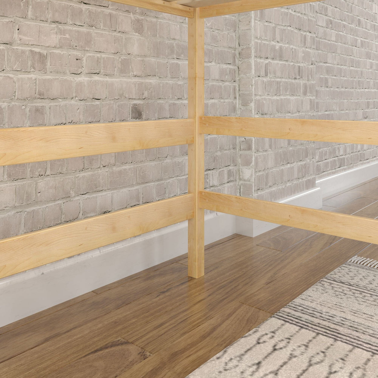 Wooden bed frame next to exposed brick wall with hardwood floor and area rug.