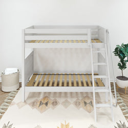 White wooden loft bunk bed with ladder in a modern bedroom setting with geometric rug and potted plant.