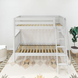 White wooden bunk bed with ladder in a modern bedroom setting, featuring a geometric rug and decorative plant.