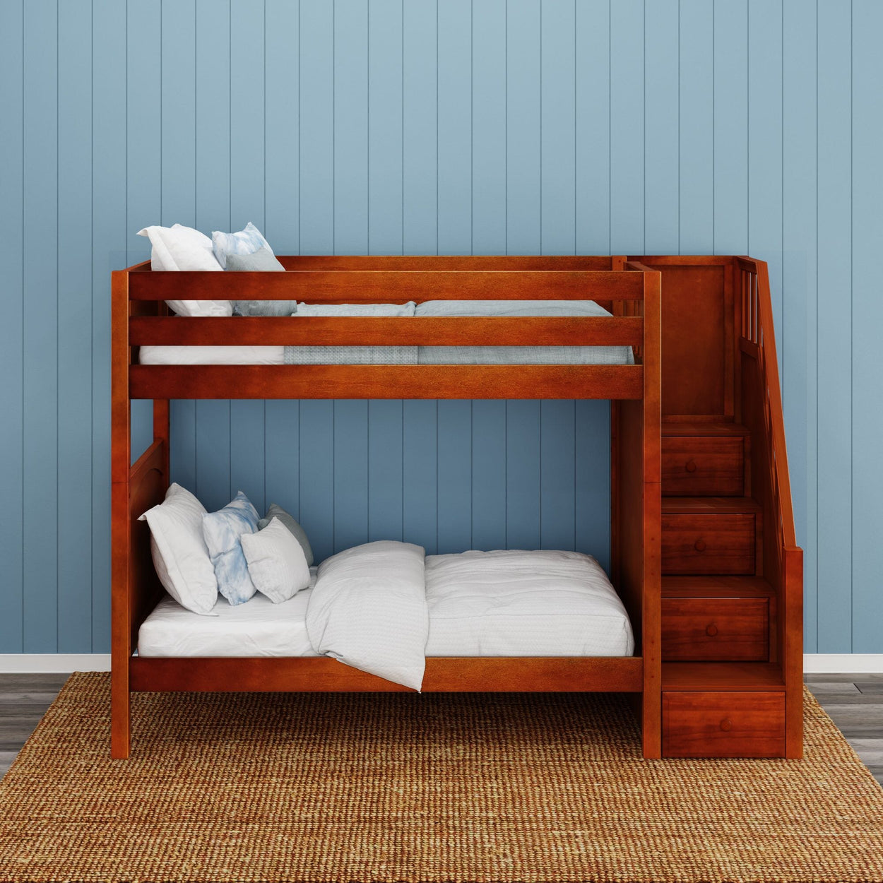 Wooden bunk bed with built-in stairs against a blue paneled wall, featuring a natural woven rug.