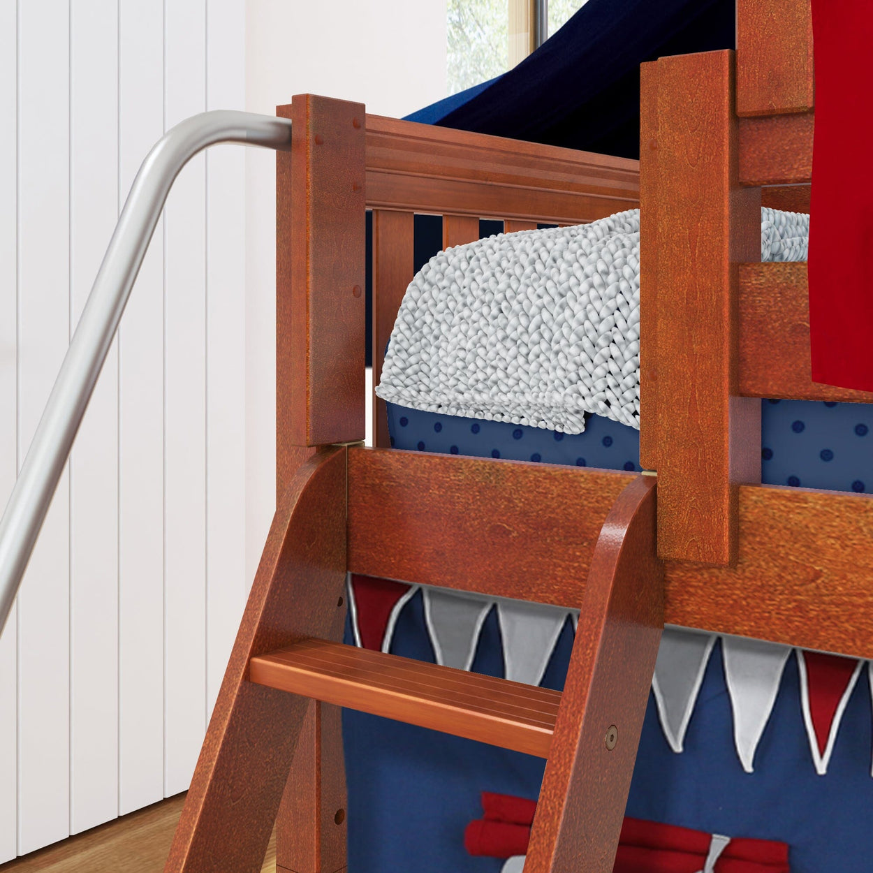 Rustic wooden bunk bed with a ladder, featuring a cozy knitted blanket and vibrant navy-themed bedding.
