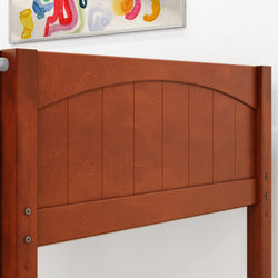 Wooden headboard with curved design and abstract painting on white wall background.