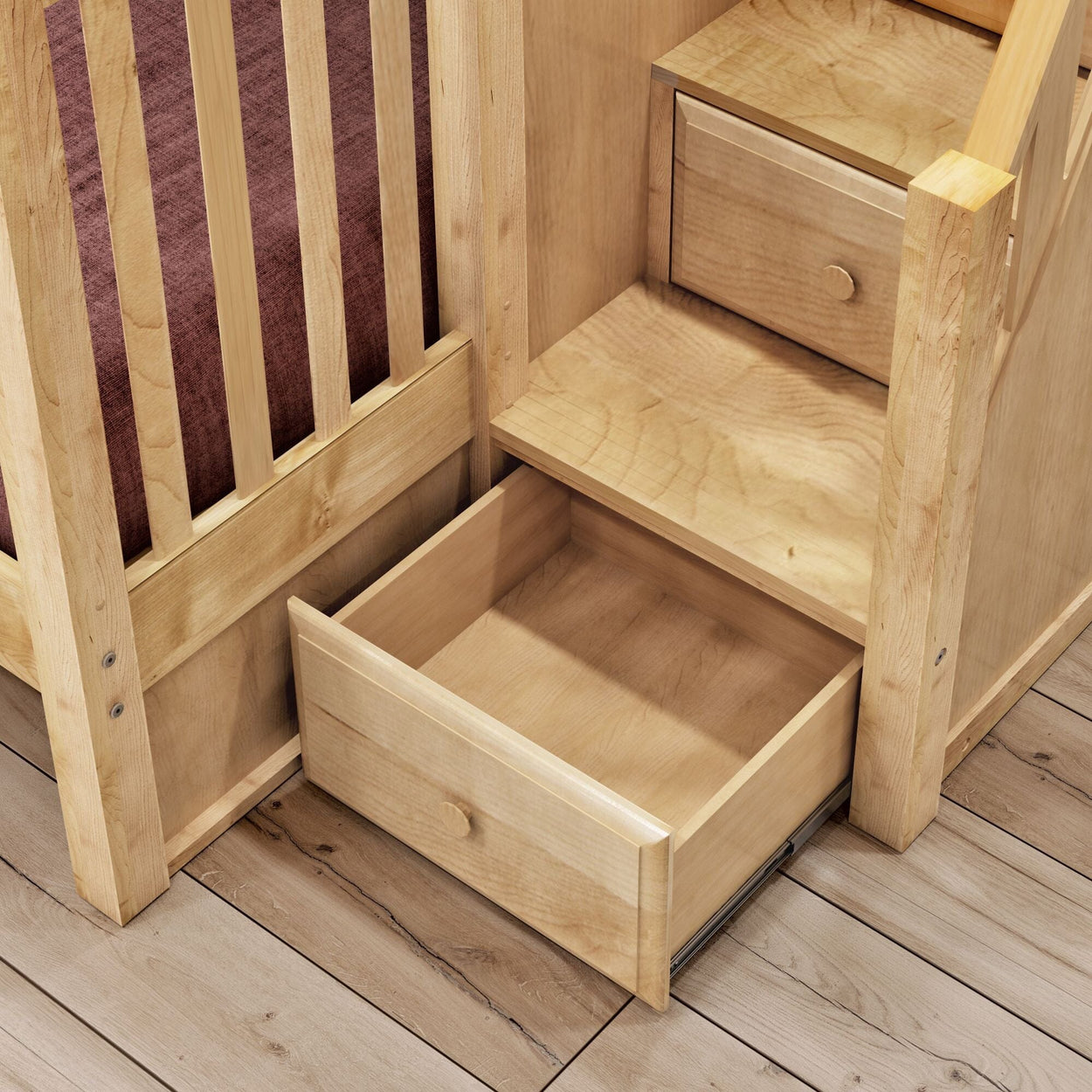 Wooden bunk bed with integrated storage steps and open drawer on wooden floor.