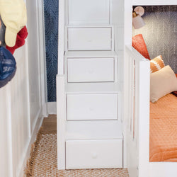 White bunk bed stair drawers with cozy bedding and decorative pillows in a modern bedroom setting.