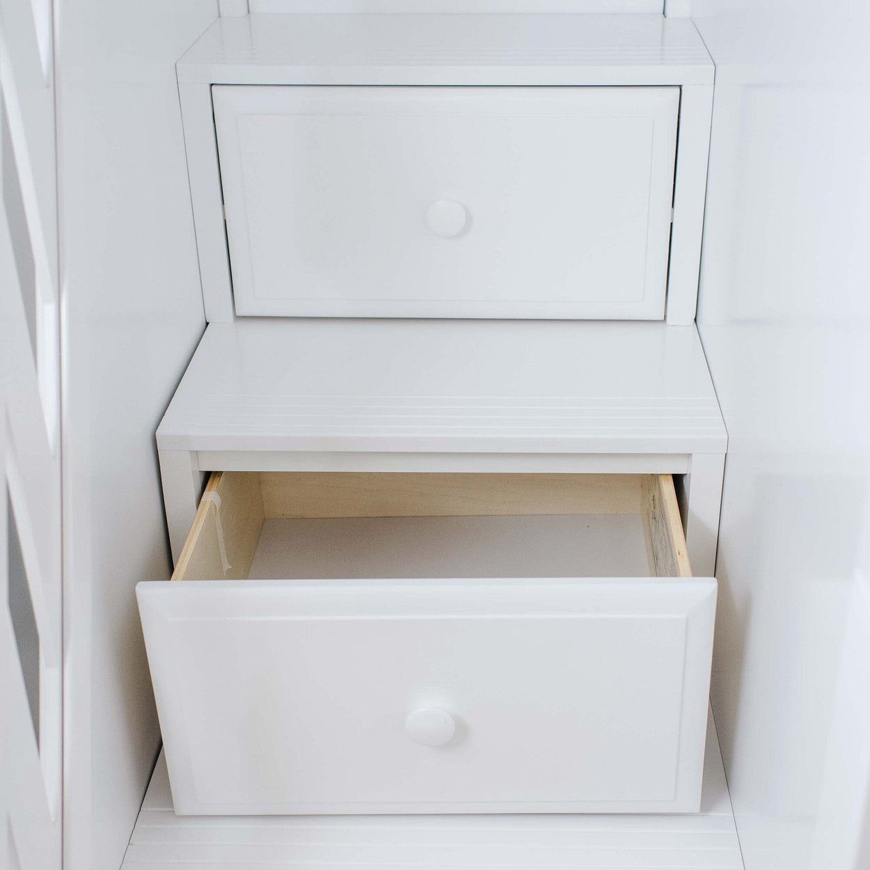 White wooden cabinet with open drawer showcasing storage space.