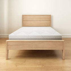 Modern wooden bed frame with a comfortable mattress in a minimalist bedroom setting.