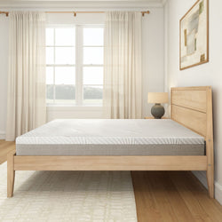 Modern minimalist bedroom with wooden bed frame and comfortable mattress in bright natural light.