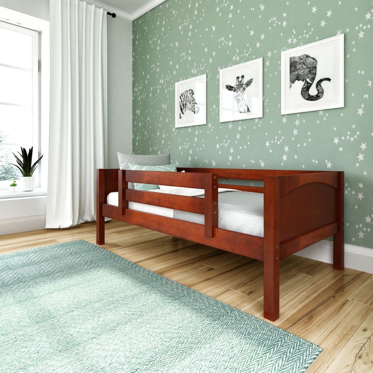 Wooden toddler bed in a star-themed room with green walls and framed animal artworks.