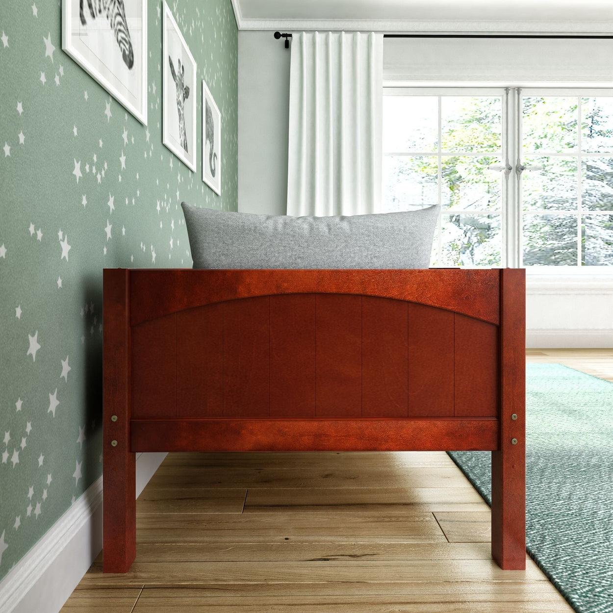Wooden toddler bed with gray pillow in a star-themed green-walled bedroom.