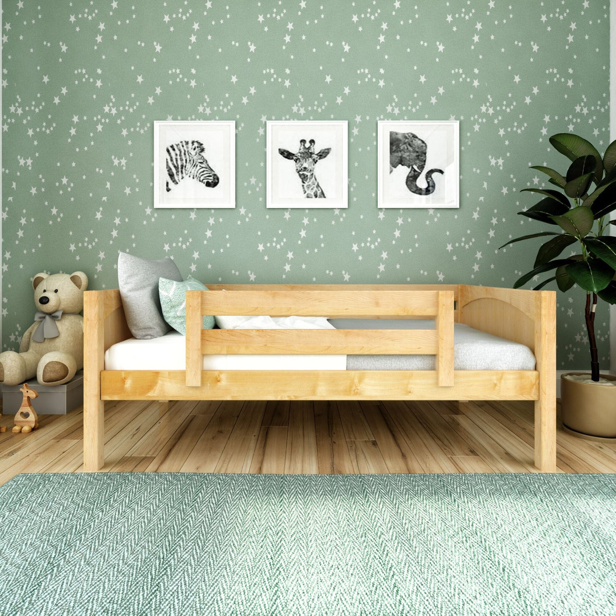 Toddler bed with animal wall art and teddy bear in cozy nursery room.