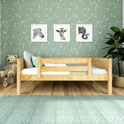 Toddler bed with animal wall art and teddy bear in cozy nursery room.