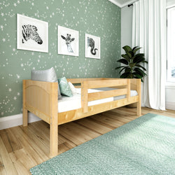 Cozy children's bedroom with wooden bed, star-patterned green wallpaper, and framed animal artwork.
