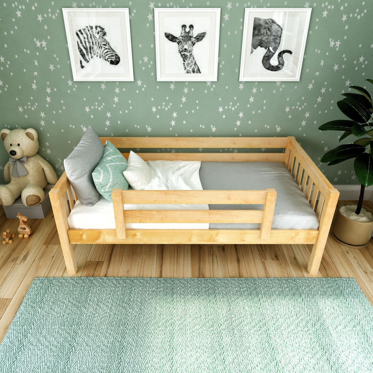 Wooden toddler bed with gray bedding, surrounded by star-patterned green wallpaper, illustrated animal portraits, and a plush teddy bear on a wooden floor.