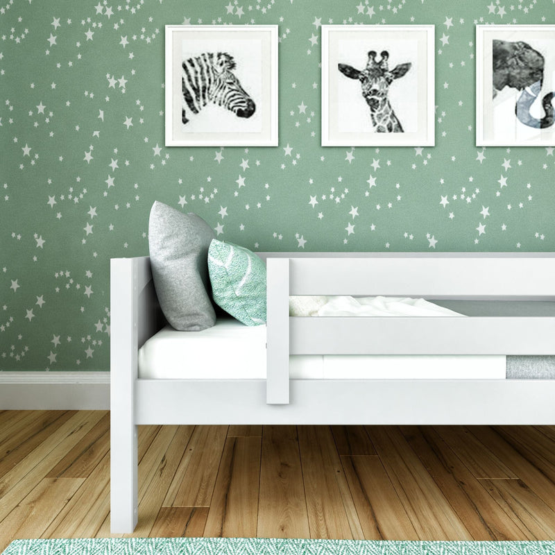 Kids bedroom decor: white bunk bed with teal pillows against mint green star wallpaper, framed zebra and giraffe wall art on hardwood floor