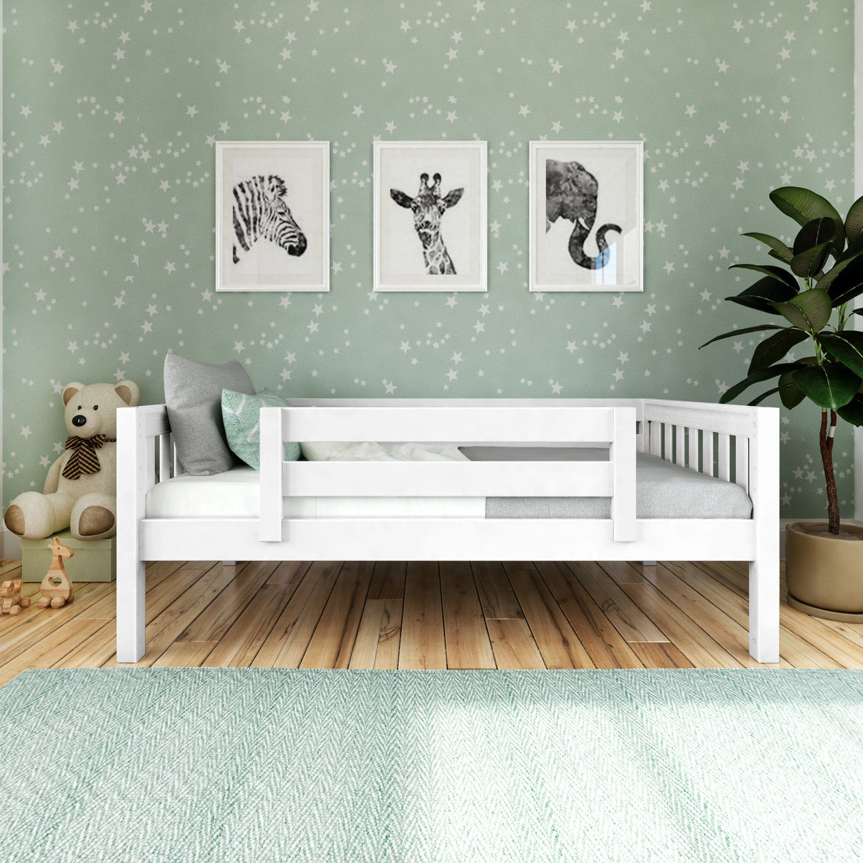 Children's bedroom with white toddler bed, animal wall art, green star-themed wallpaper, and plush teddy bear.