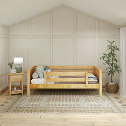 Cozy bedroom with wooden bed frame, stylish end table with lamp, and a decorative indoor plant.